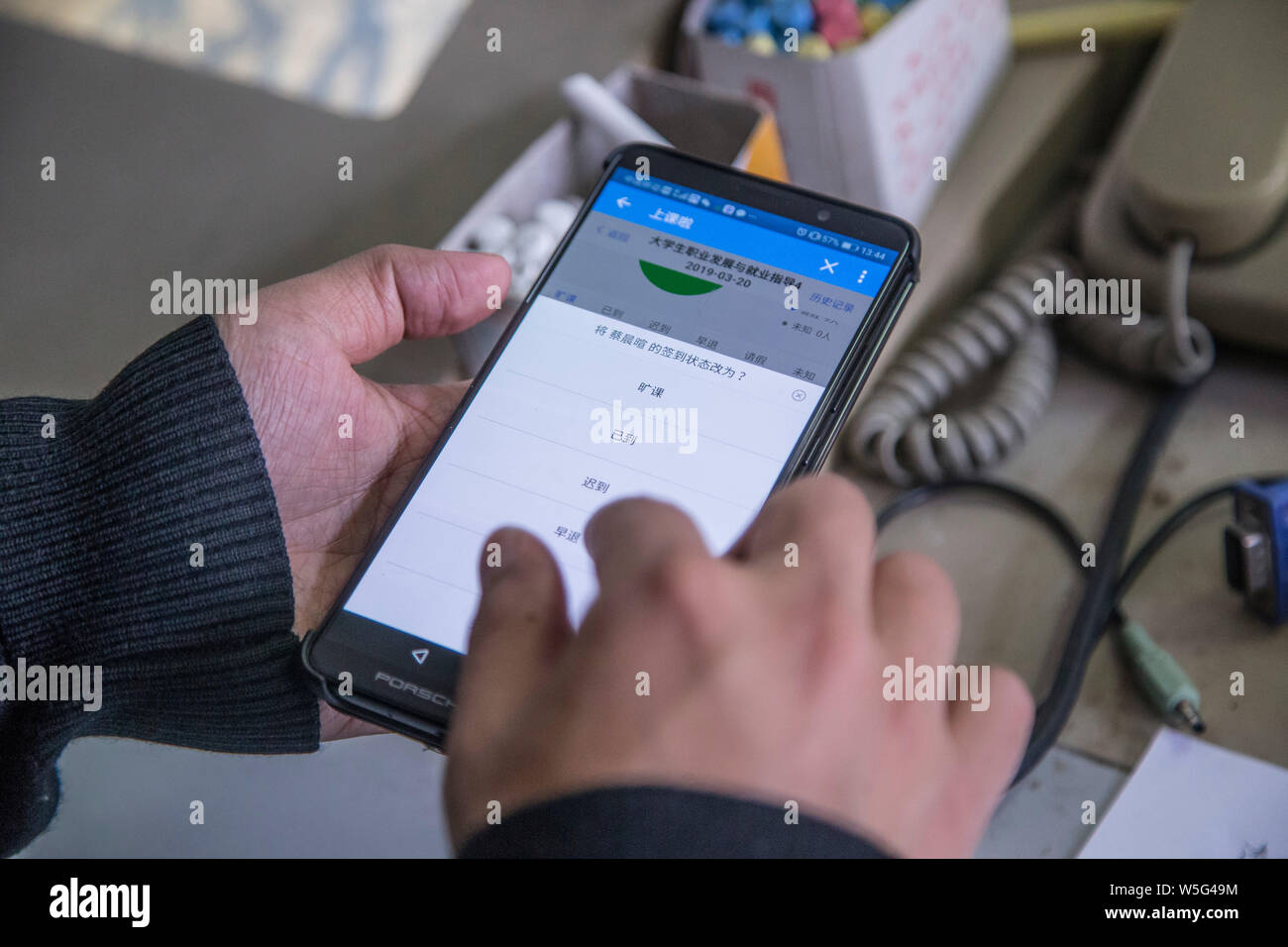 Un insegnante utilizza l'App che consente il tracciamento delle presenze degli studenti sul suo smartphone in una classe a Hangzhou dianzi University di Hangzhou, Oriente Cina Foto Stock