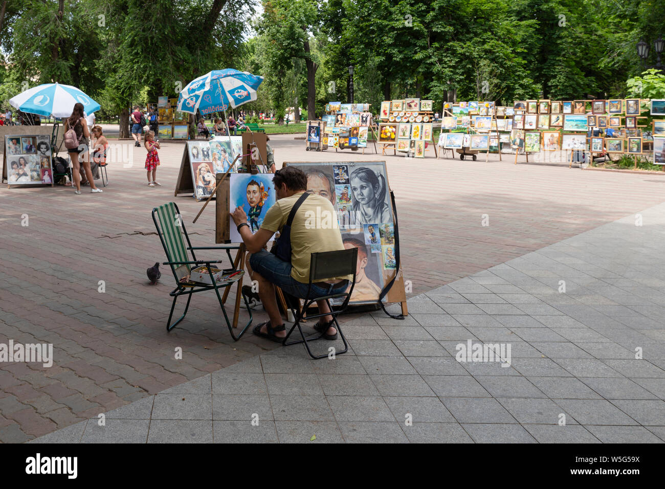 Ucraina Odessa, Preobrazhenska Street, 12 giugno 2019. Un artista di strada lavorando su uno stile cartoon ritratto dipinto nella piazza di fronte alla Foto Stock