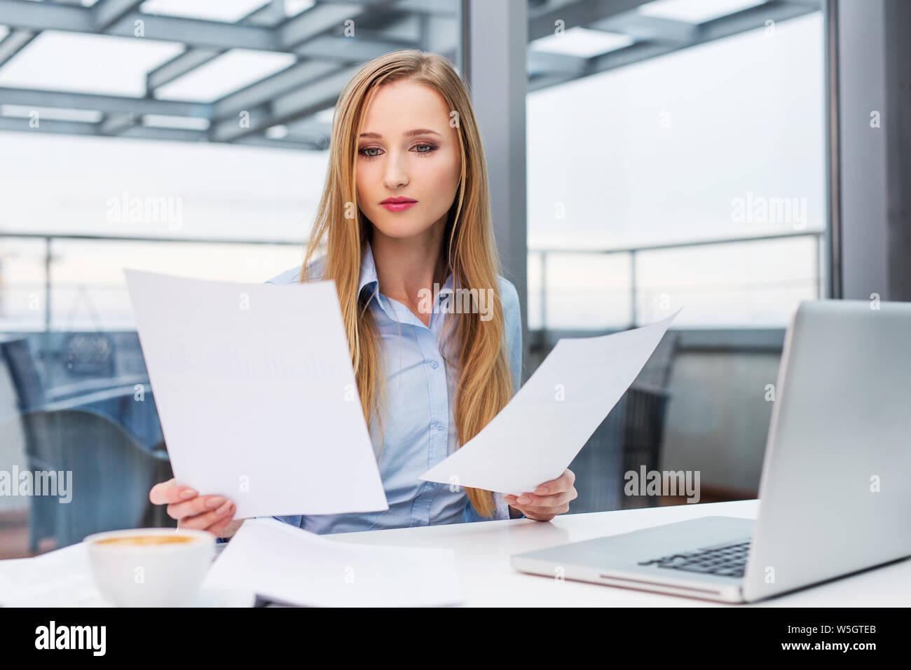 Young business woman comparazione di documenti in ufficio Foto Stock