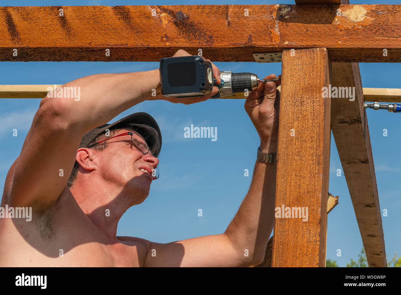Un artigiano costruire casa estiva all giraviti a batteria Foto Stock