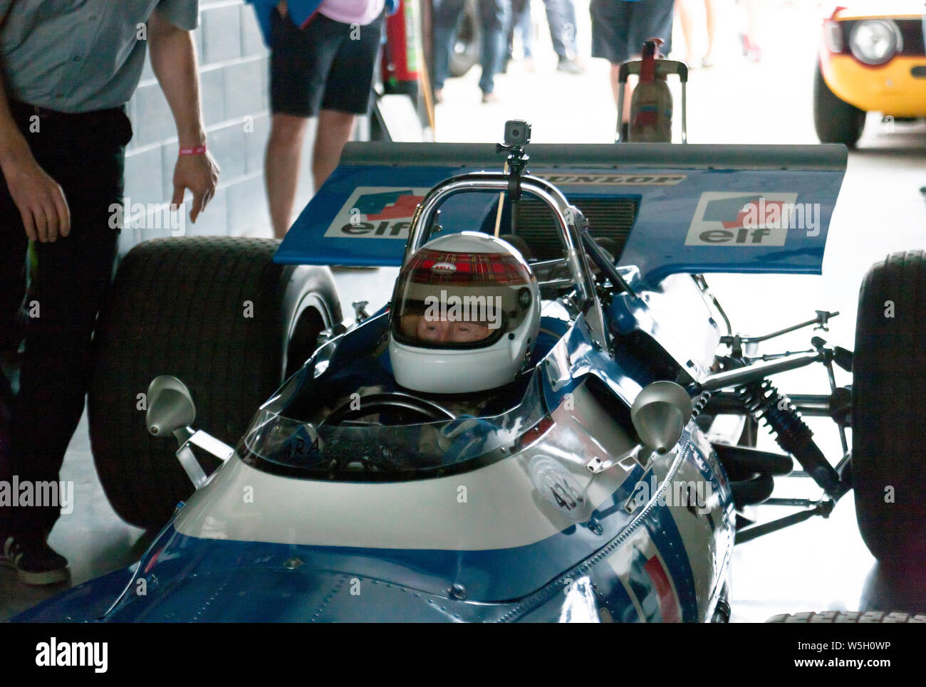 Close-up di Sir Jackie Stewart seduto nell'abitacolo della sua 1969 vincente Matra MS80-02, prima del completamento di alcuni ad alta velocità a giri intorno a Silverstone Foto Stock