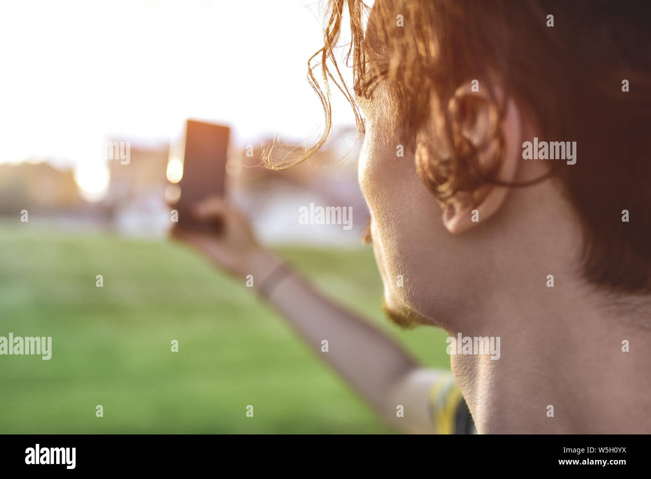 Close-up guy prende le immagini della natura, con splendide viste sul suo smartphone. estate umore Foto Stock