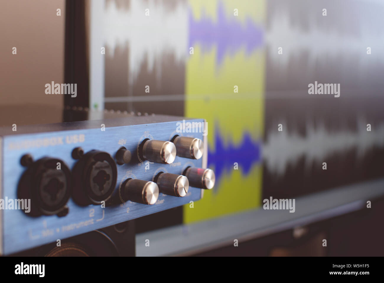 Close up di un Audiobox USB esterne tavola armonica. Sullo sfondo un sound editing software può essere visto su uno schermo. Foto Stock
