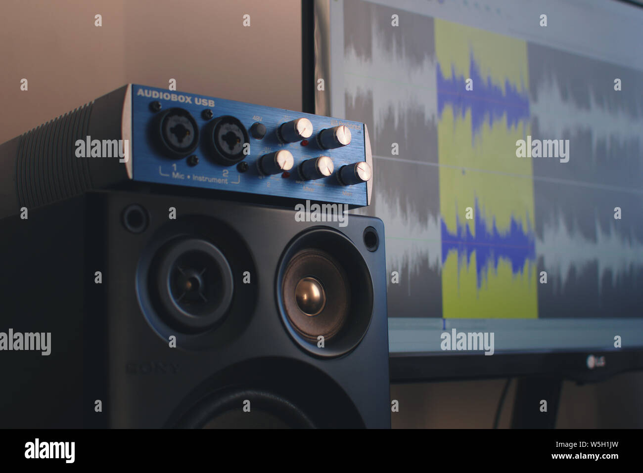 Close up di un Audiobox USB esterne tavola armonica. Sullo sfondo un sound editing software può essere visto su uno schermo. Foto Stock