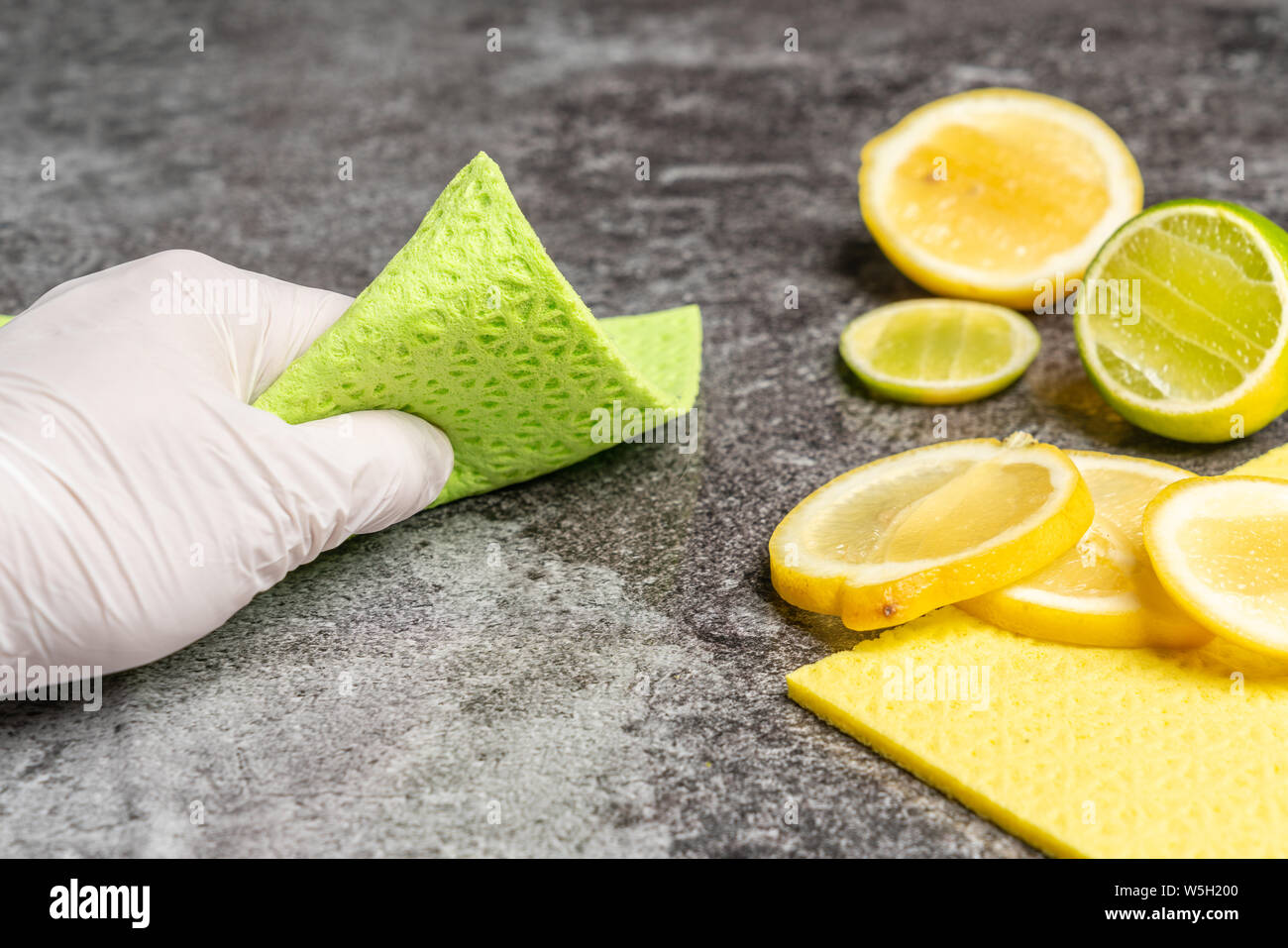 La mano è la pulizia della tabella con il limone biologico agenti di pulizia Foto Stock