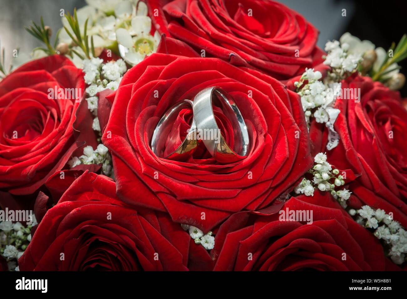 Foto simbolico sul tema del matrimonio e matrimoni. Uppiger decorazioni floreali su auto nozze. Le fedi sono un simbolo di lealtà al supporto di persone, cioè i coniugi. | Utilizzo di tutto il mondo Foto Stock