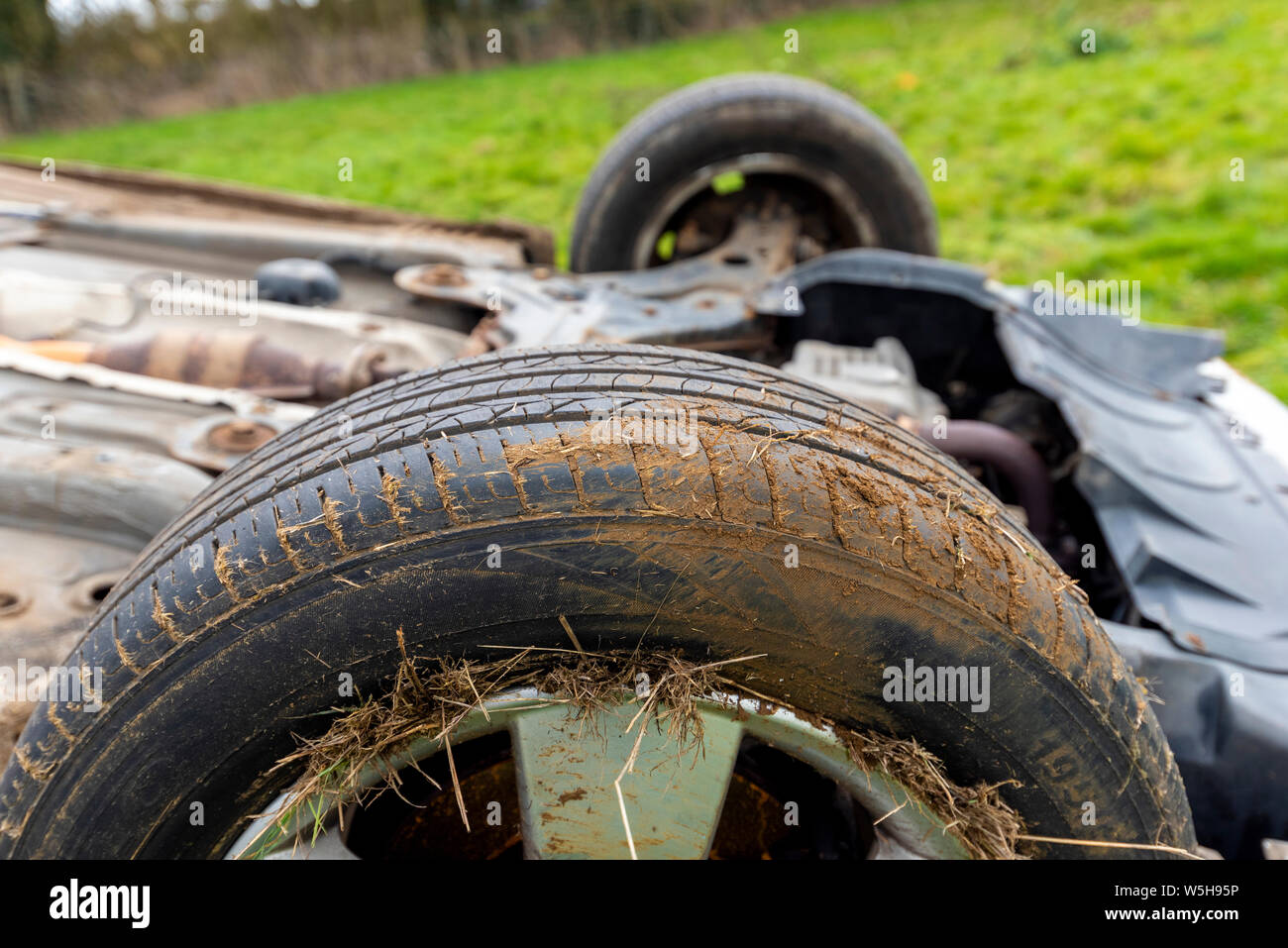 Car crash. I giovani conducenti veicolo capovolto. Non fatale incidente causato da un eccesso di velocità e la pioggia. Driver inesperti / criminalità rurale / furto di auto / RTC. Regno Unito Foto Stock