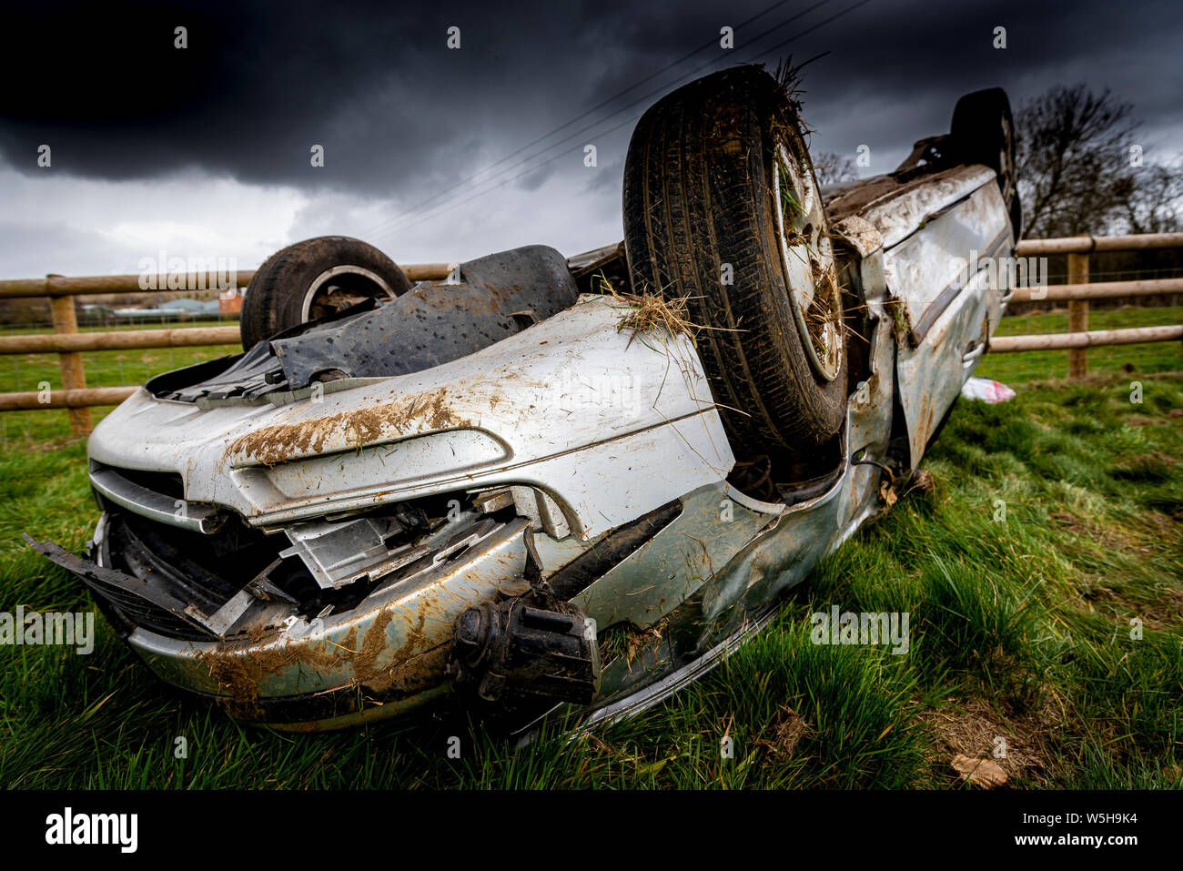 Car crash. I giovani conducenti veicolo capovolto. Non fatale incidente causato da un eccesso di velocità e la pioggia. Driver inesperti / criminalità rurale / furto di auto / RTC. Regno Unito Foto Stock