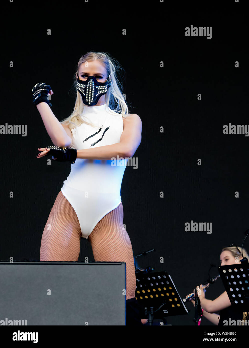 Ballerino in una maschera facciale e bianco leotard esibirsi sul palco del 2019 Liverpool International Music Festival (LIMF). Foto Stock