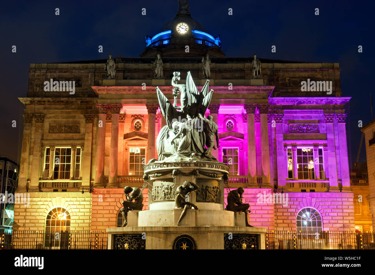 Il Monumento Nelson con il Municipio di Liverpool illuminato in LGBTQ colori davanti di orgoglio in Liverpool 2019 weekend che ha attirato un numero record. Foto Stock