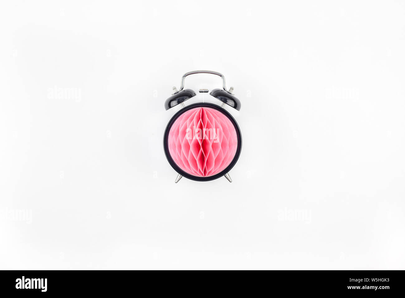 Compleanno o baby doccia invito alla festa del modello di scheda. Nero orologio sveglia con rosa di carta a nido d'ape sfera su sfondo bianco. Creative top concettuale Foto Stock