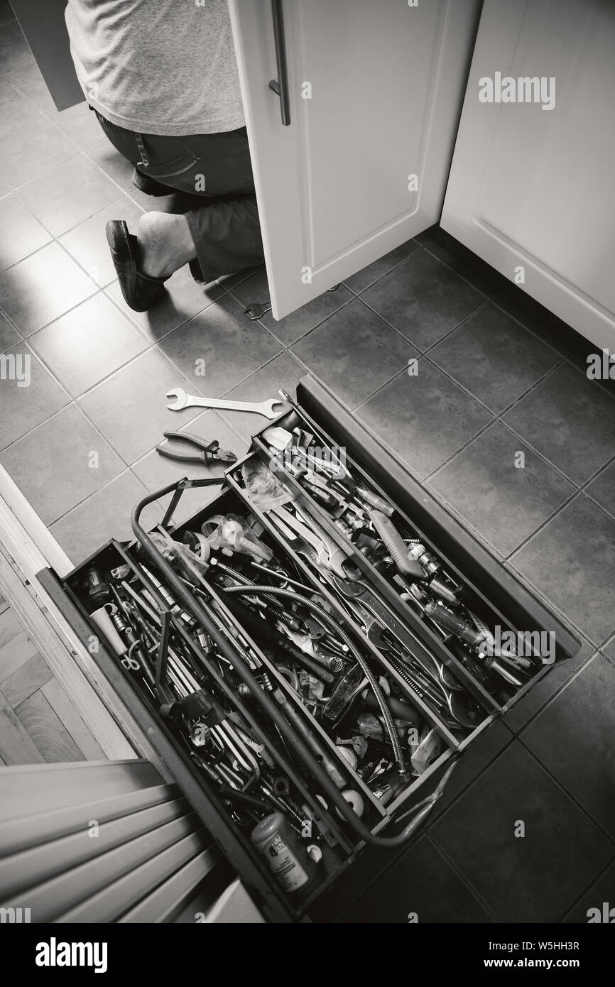 Stile di vita normale scena, il lavoratore e i suoi utensili in cucina, la manutenzione di qualcosa. Foto Stock