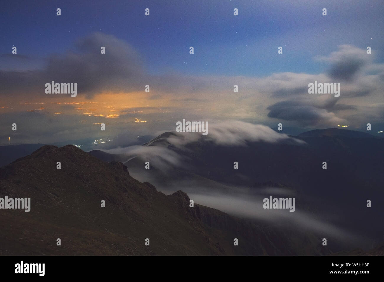 Le nuvole e la nebbia in una notte moonlighted sulle montagne Agrafa Foto Stock