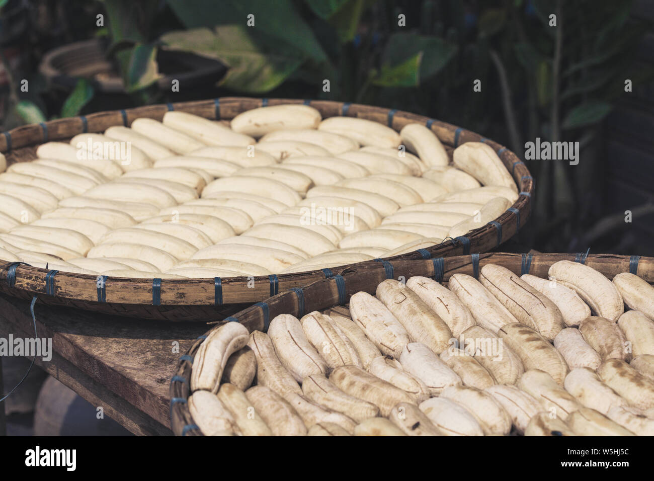 Sbucciate le banane essiccamento in cesti di bambù esposta al sole in Laos Foto Stock