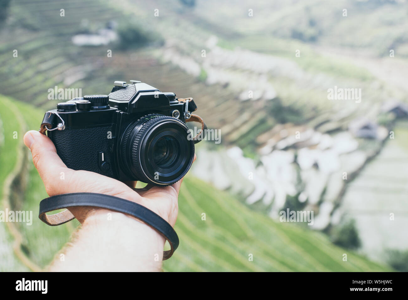 Mano azienda nero film vintage fotocamera con Sapa terrazze di riso su sfondo, Vietnam Foto Stock