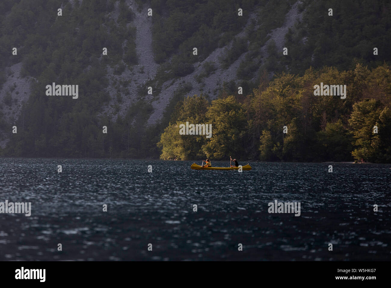 Giovane paddling in una canoa Lago di Bohinj, Slovenia, Europa Foto Stock