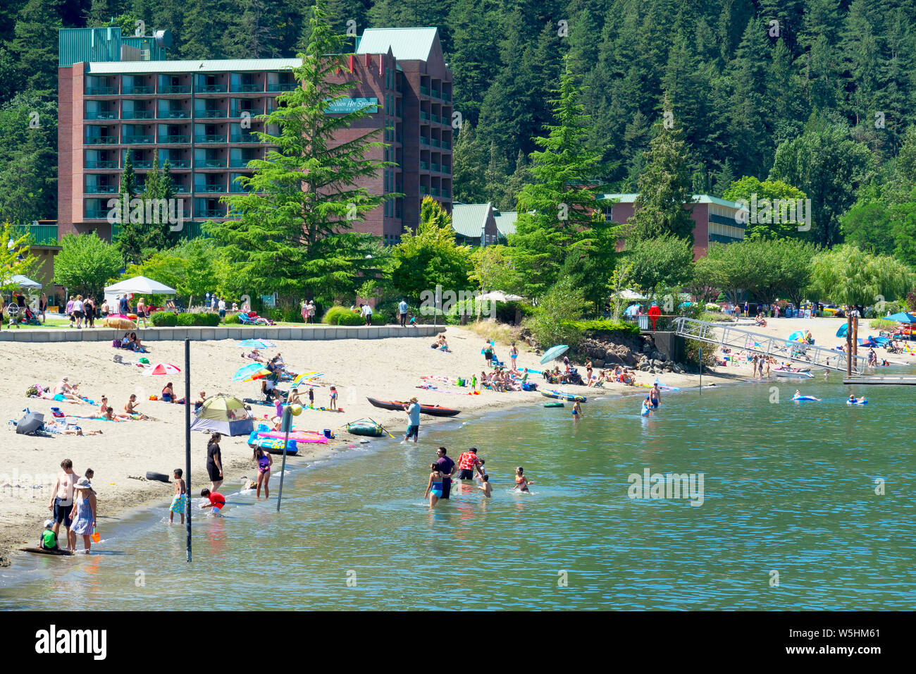 L'hotel presso l'Harrison Hot Springs Resort and Spa con gli amanti della spiaggia che si godono la spiaggia di sabbia su un caldo 28 luglio 2019. Situato sul lago Harrison, B. C. Foto Stock