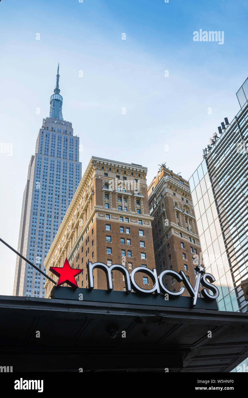 New York shopping, vista di un Macy's segno sulla West 34th Street con la mitica Empire State building in distanza, New York City, Stati Uniti d'America Foto Stock
