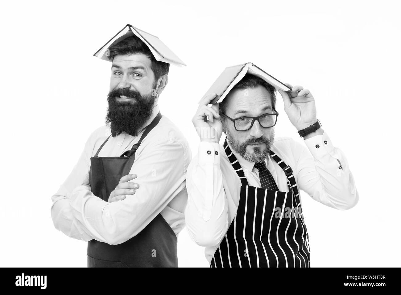 Gli uomini barbuti grembiule libro lettura circa culinario. Gli uomini in casa di carica. Alcuni problemi. Mansioni domestiche. Prenota come tetto sulla testa. Uso domestico è noioso. Chi regole in casa. Responsabilità della famiglia. Foto Stock