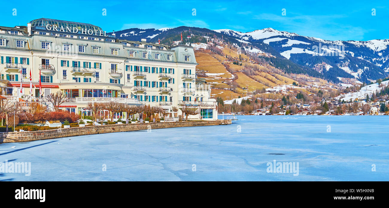 ZELL AM SEE, Austria - 28 febbraio 2019: Il lussuoso Grand Hotel, situato sulla banca di congelati lago Zeller See con scenic mountain range su backgrou Foto Stock