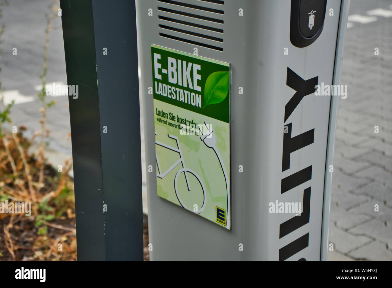 Wolfsburg, Germania, Luglio 7, 2019: Ricarica post per una carica elettrica alla stazione con una connessione per la ricarica di biciclette elettriche gratis Foto Stock
