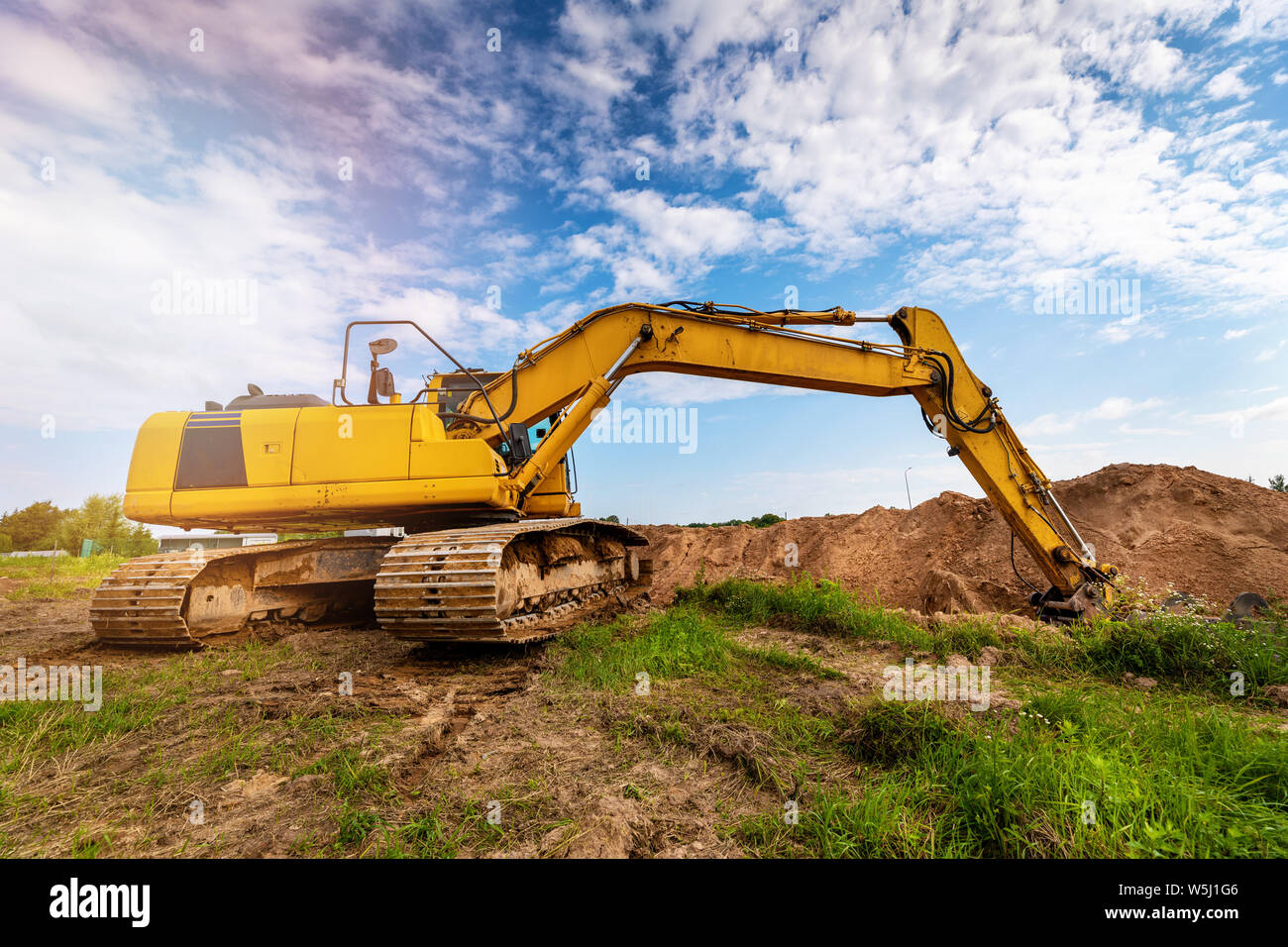 Escavatore industriale lavorando sul sito di costruzione di scavare una fossa Foto Stock