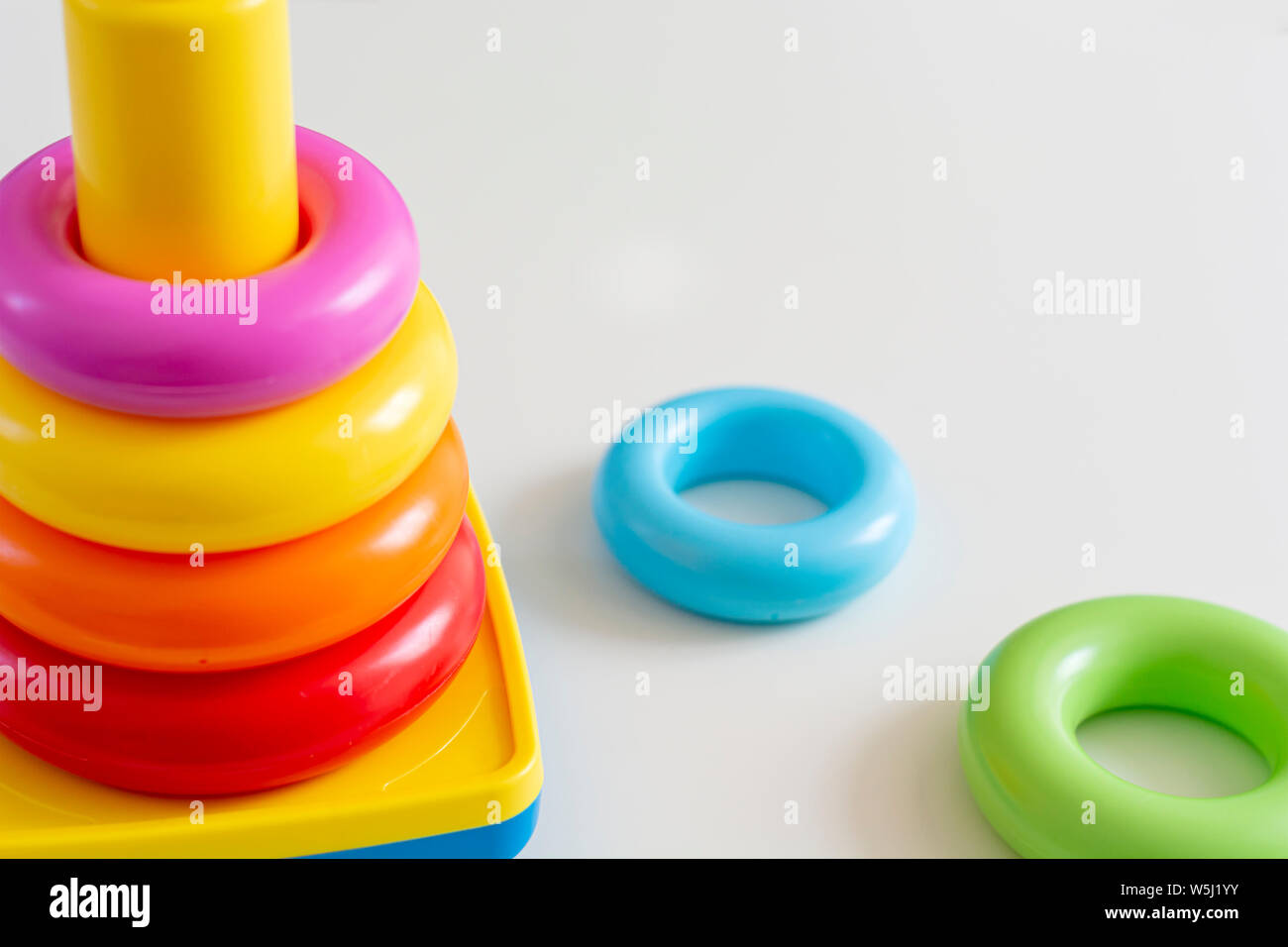 Colorate anelli di plastica impilati in una torre. Giocattoli per neonati. Foto Stock