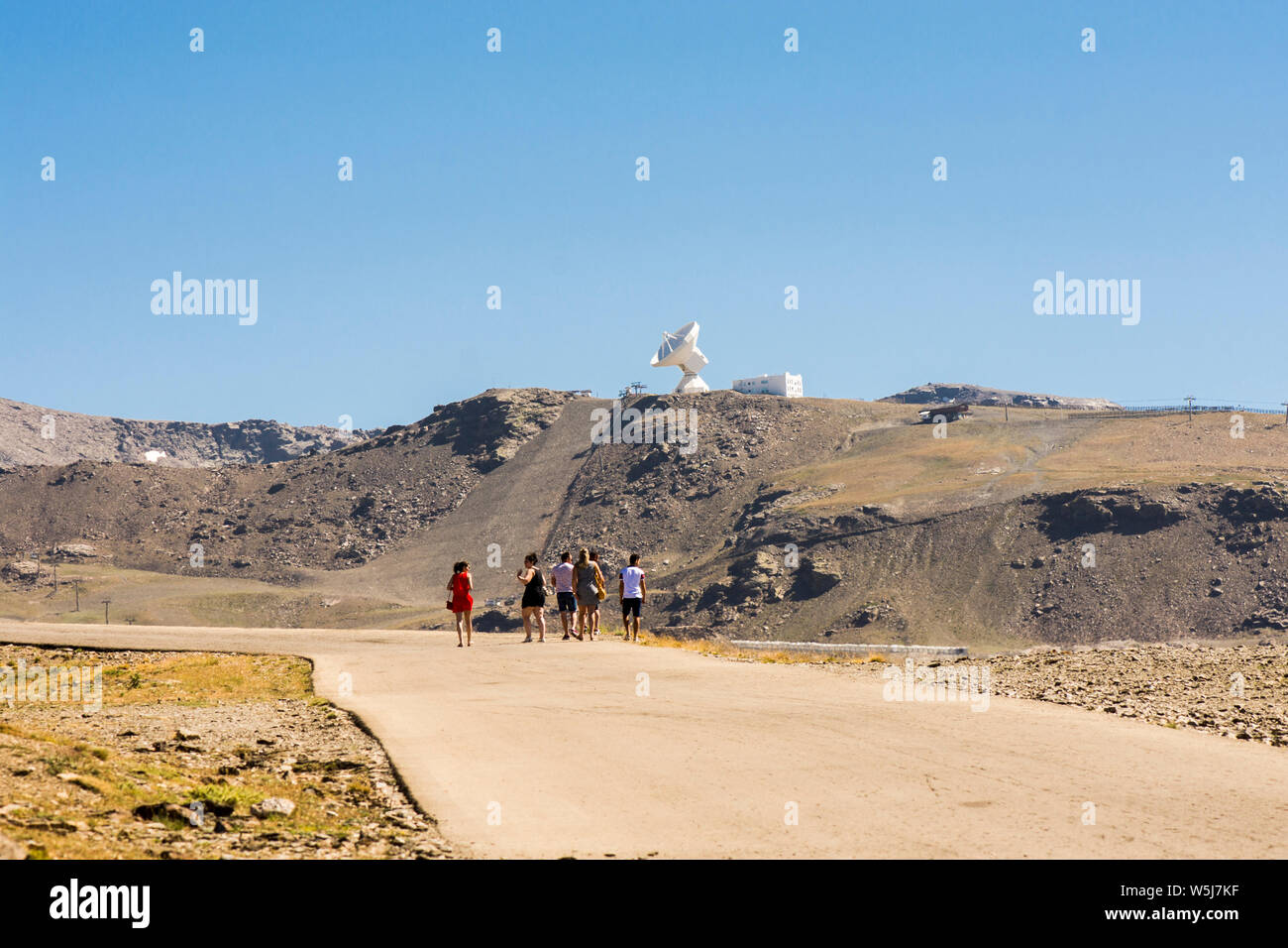 Un gruppo di persone su strada a piedi per Pico de Veleta, vertice, con osservatorio, radio astronomia, radio telescopio, Sierra Nevada, Granada, Spagna. Foto Stock