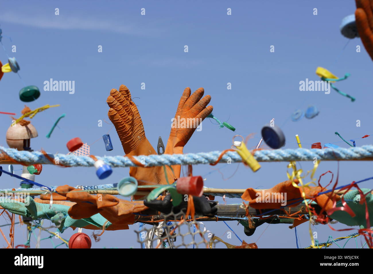 Varie voci di flotsam e jetsam lavato fino sulla riva del mare che sono stati raccolti e collocati in un disegno astratto Foto Stock