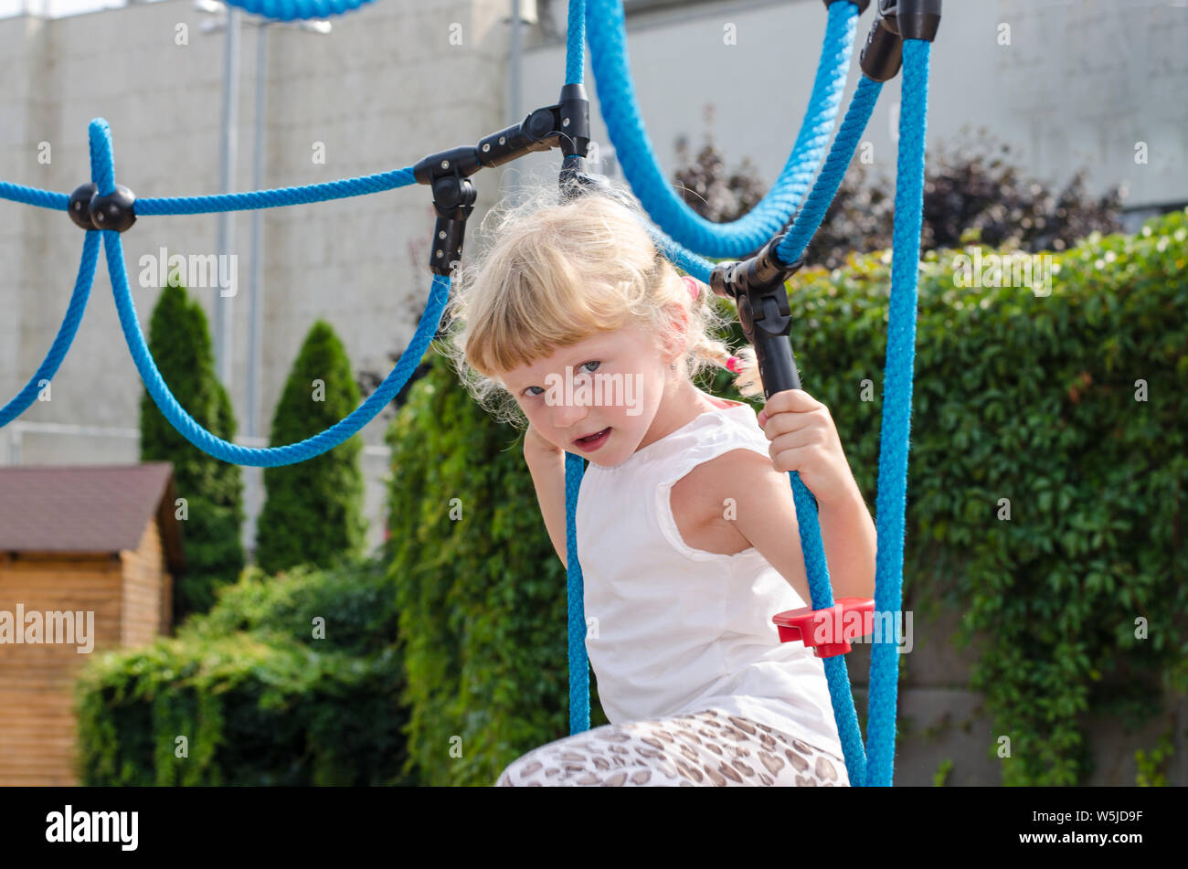 Bella ragazza bionda giocando sul parco giochi Foto Stock