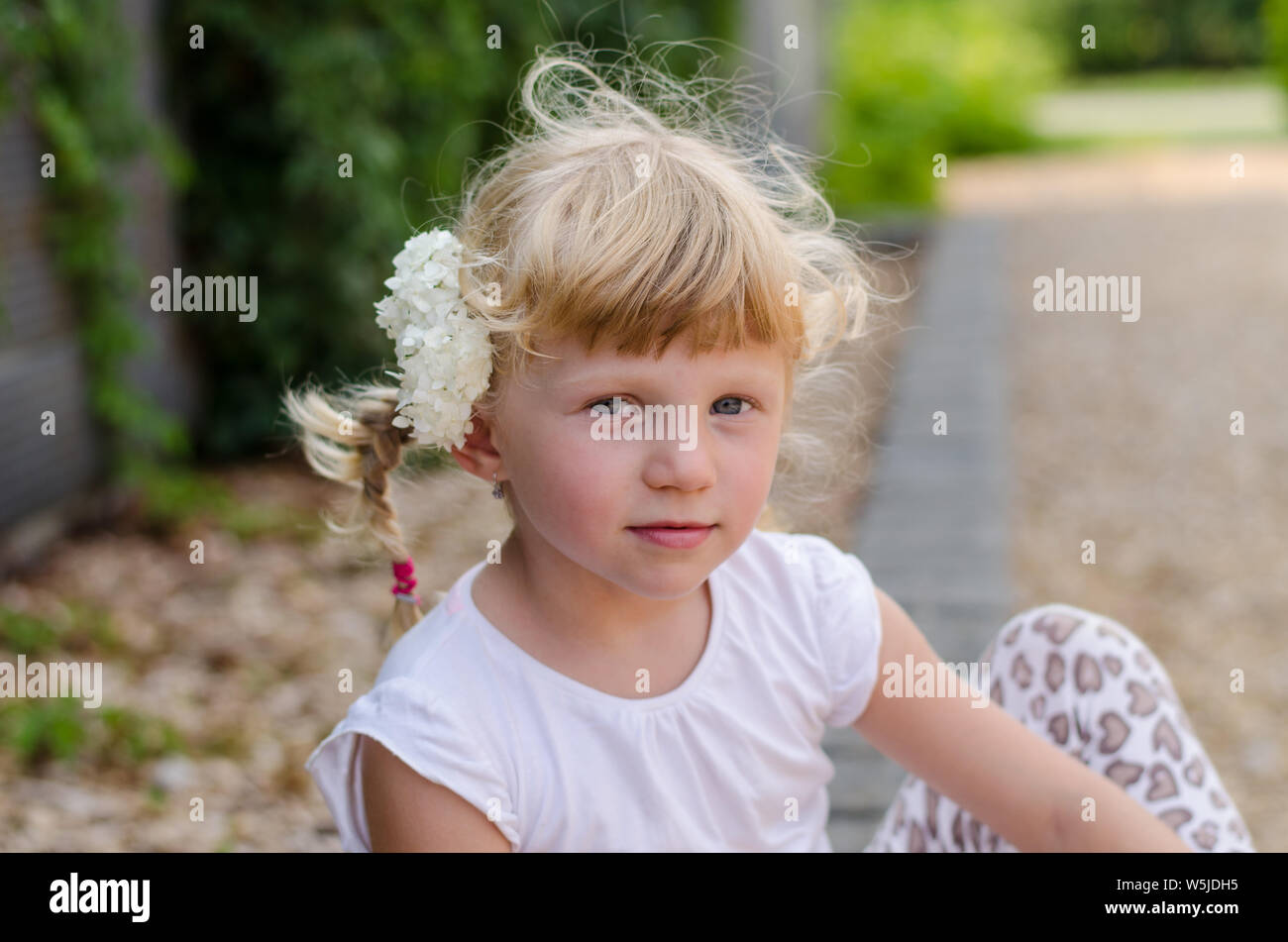 Bella ragazza bionda con fiore nei capelli Foto Stock