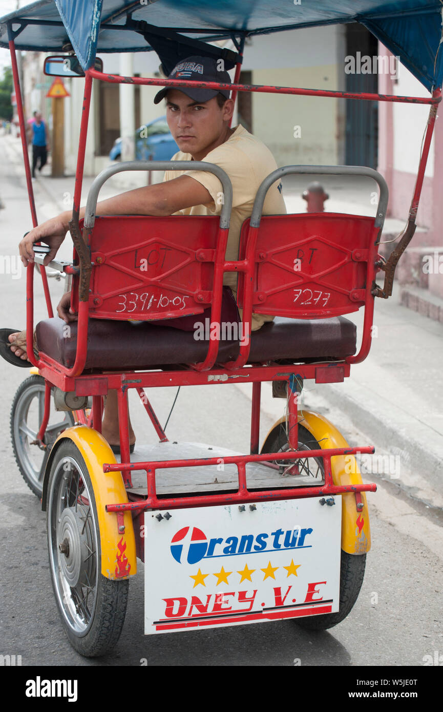 I giovani cubani taxi bicicletta chauffeur si rilassa sulla sua bicicletta Foto Stock