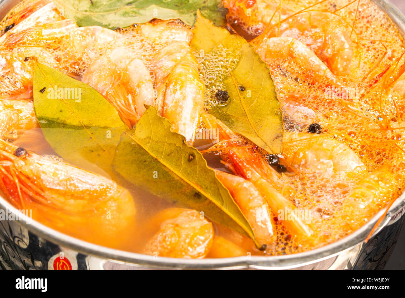 Atlantic i gamberetti sono cotti con la foglia di alloro e il pepe della Giamaica in un piatto di pesata in acciaio inox. Foto Stock