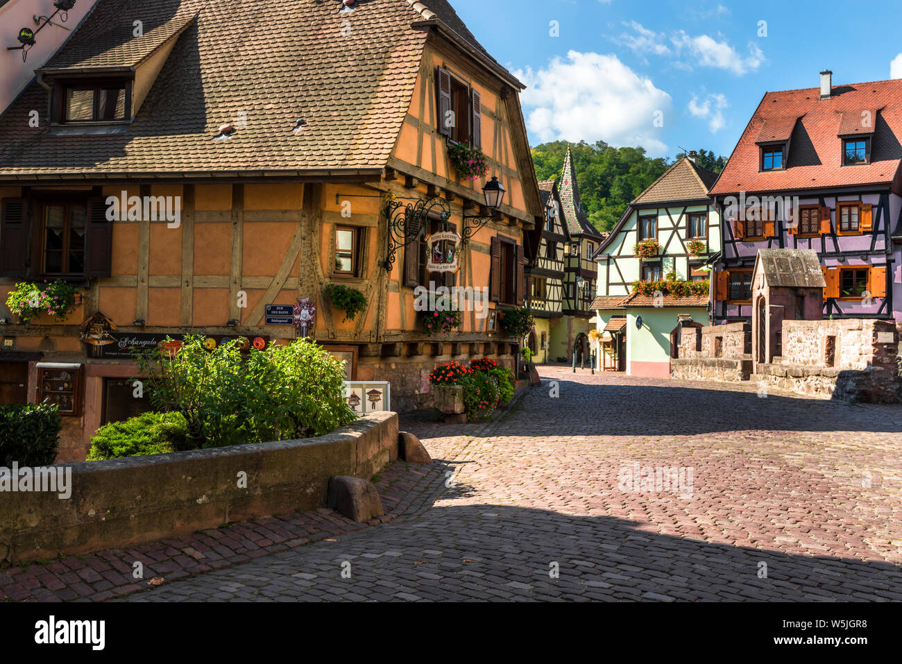 Il pittoresco ensemble nel villaggio Kaysersberg, Alsazia, Strada del Vino, Francia, quadrato con tipiche case a graticcio e ponte di pietra Foto Stock