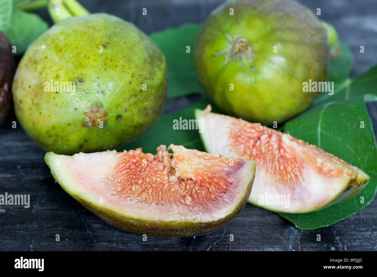 Freschi e succosi fichi al buio su un tavolo di legno Foto Stock