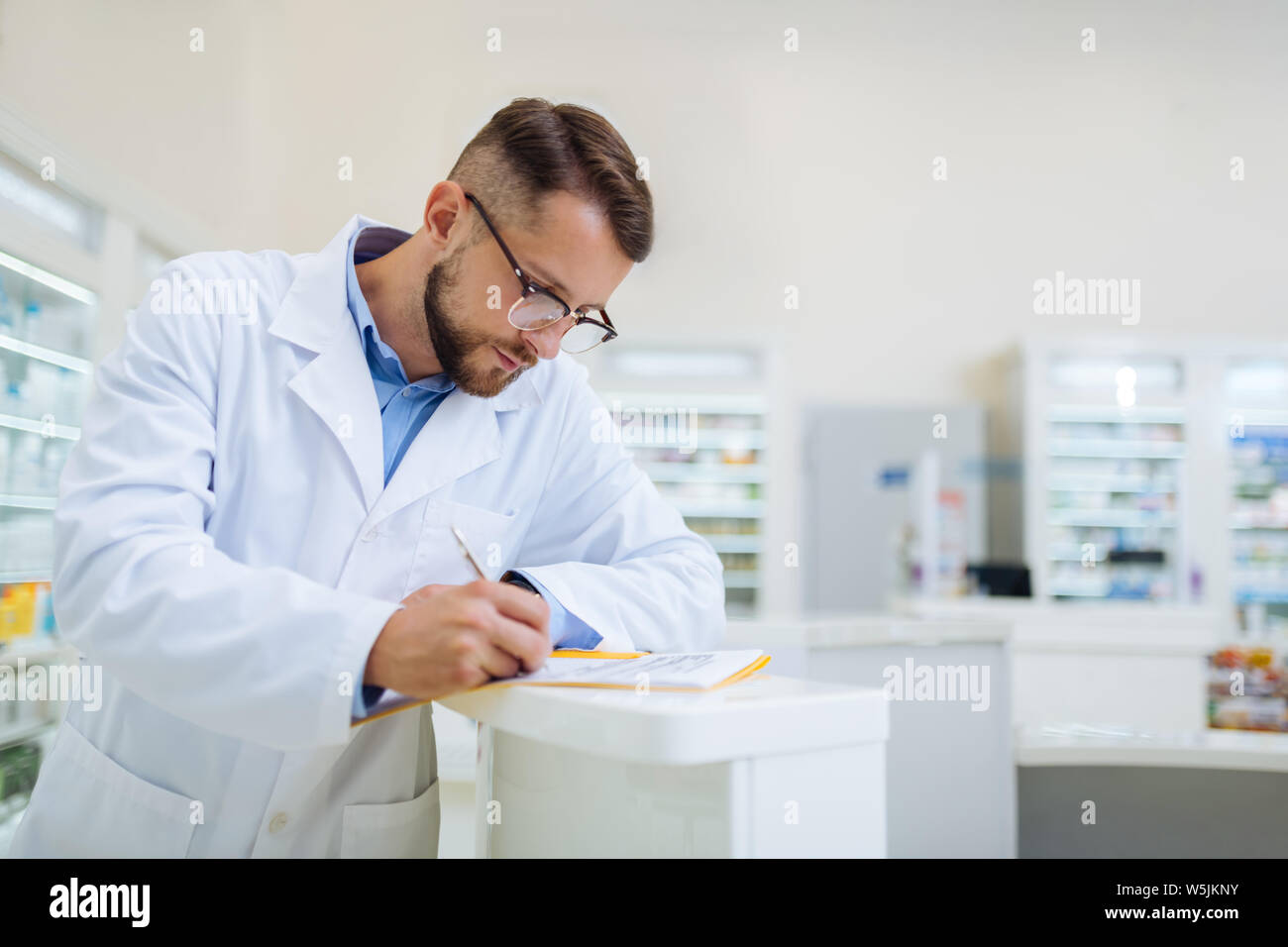 Attento persona maschio rendendo note durante la revisione Foto Stock