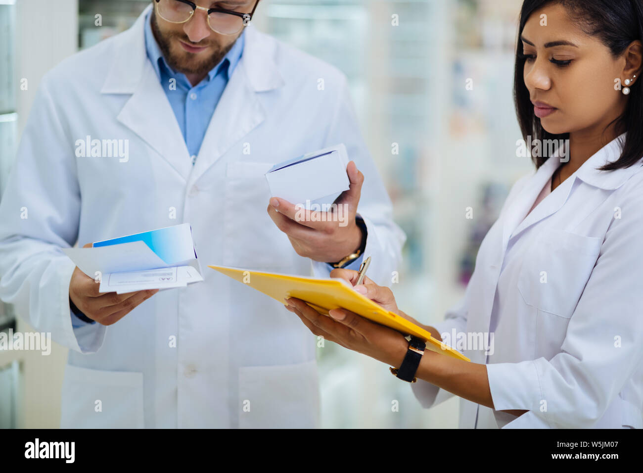 Attento femmina bruna rendendo note durante la revisione Foto Stock