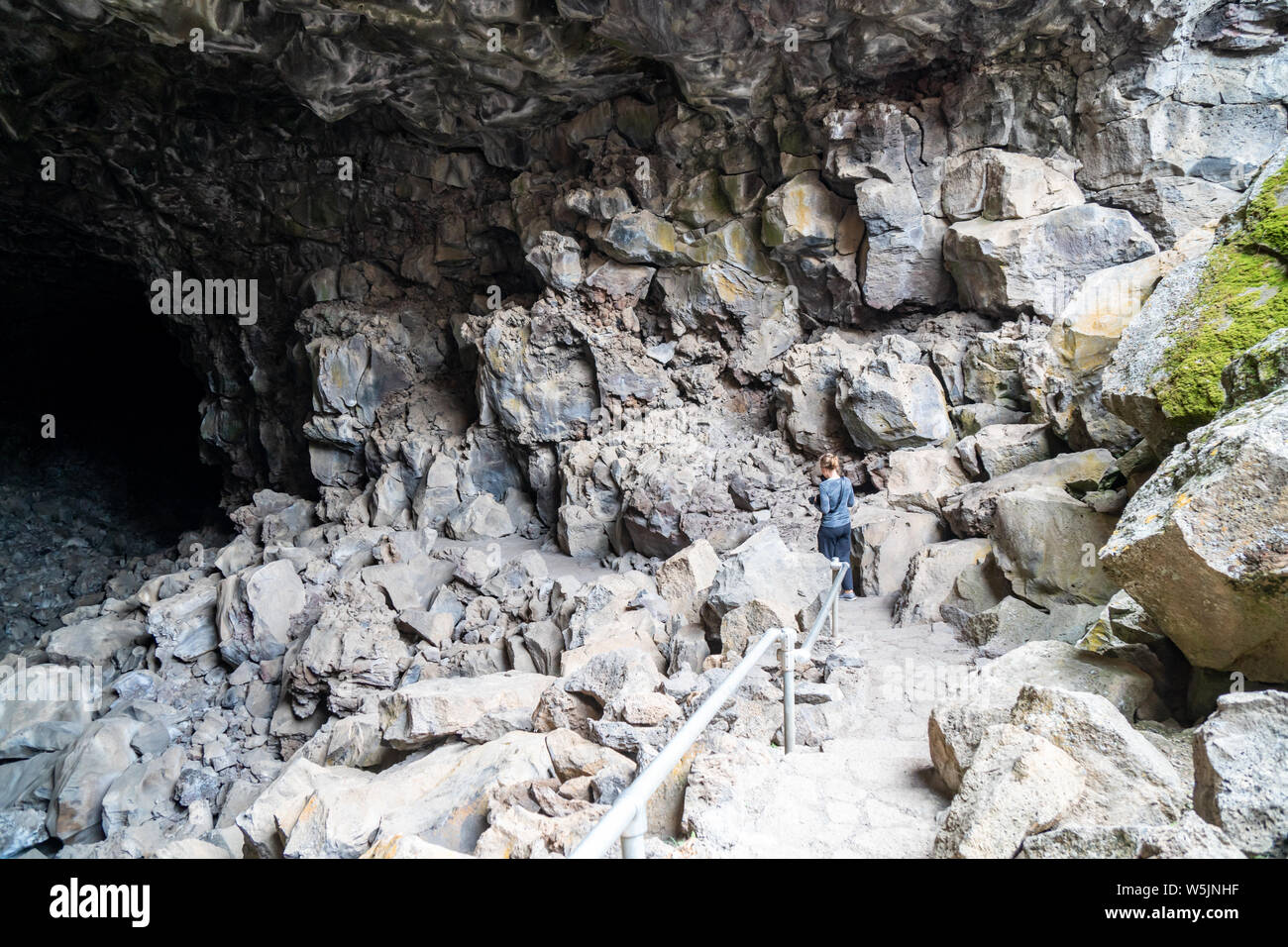Grotta di donna explorer escursioni verso il basso nel cranio grotta in letti di Lava Monumento Nazionale in California Foto Stock