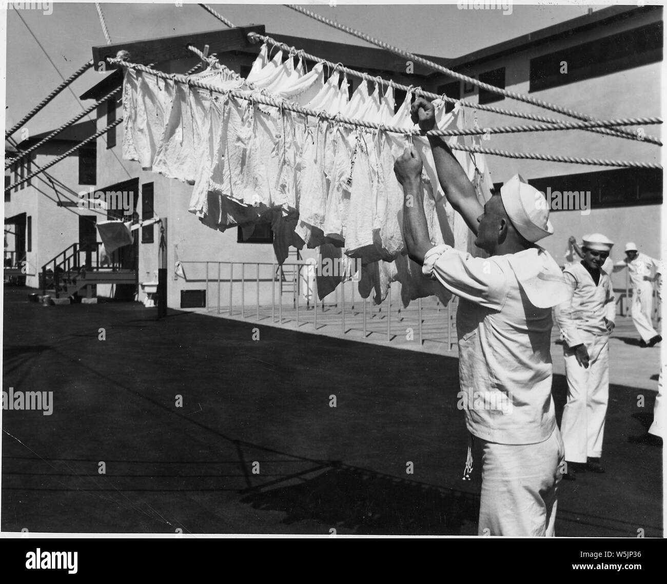 [Sailor appeso sul lavaggio biancheria giorno o forse imparare a Tie nodi o segnale di mano bandiere del Naval Training Station, San Diego, California.] Foto Stock