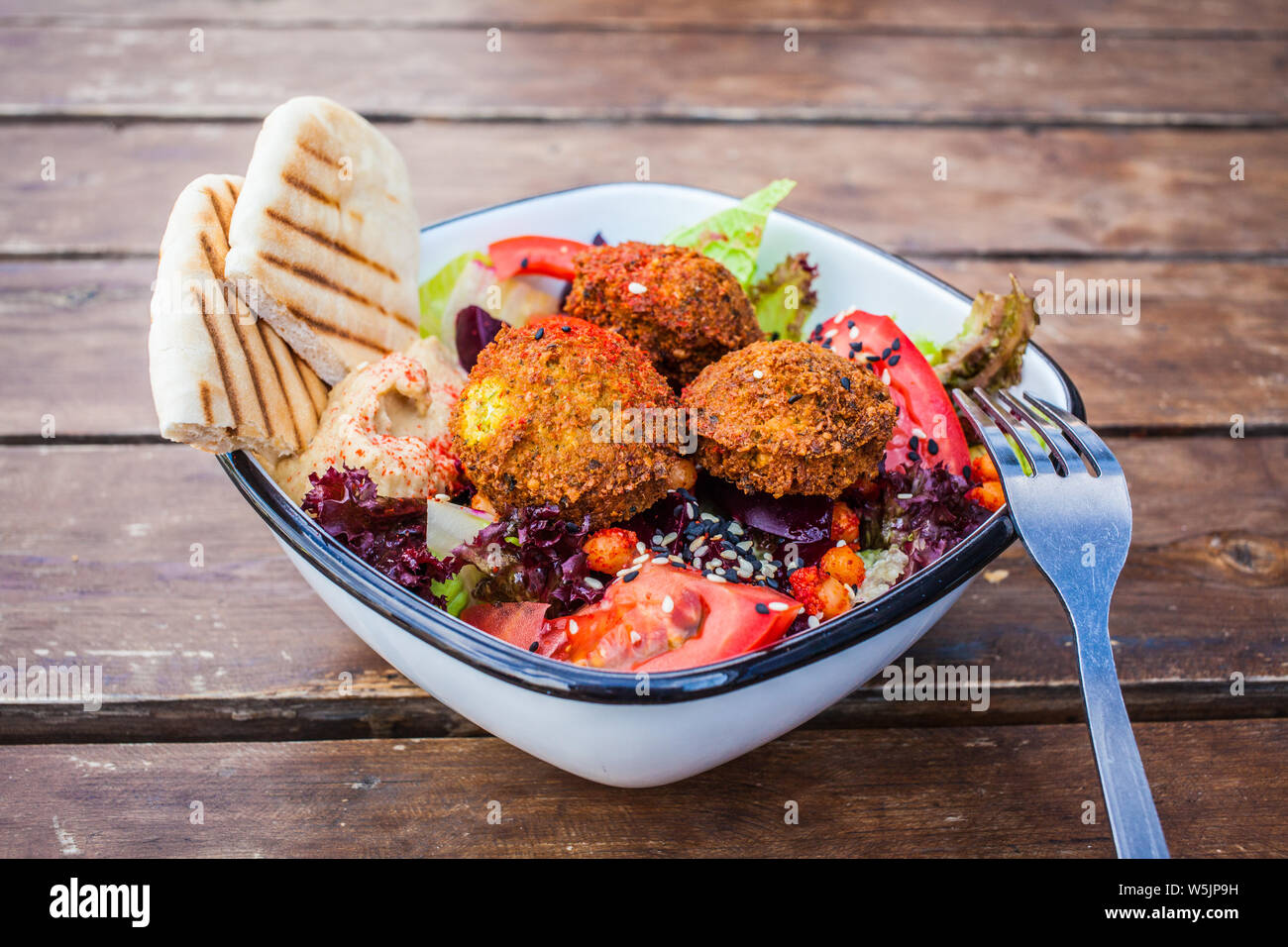 Israeliano di cibo di strada. Insalata di falafel con hummus, la barbabietola e la verdura in una ciotola in un ristorante. Foto Stock