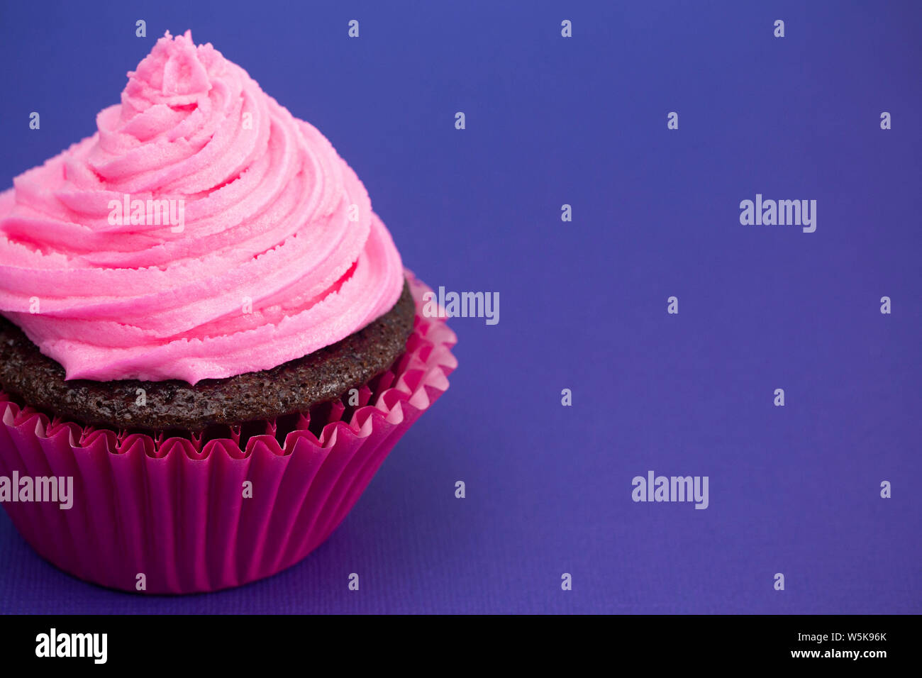 Unico smerigliato Rosa Tortina di cioccolato su una superficie di colore viola Foto Stock