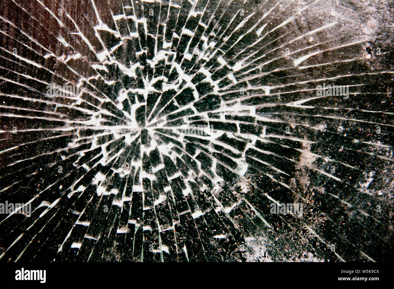 Close up orizzontale colpo di shattered shop vetro, prevalenza scuro con schegge di luce Foto Stock