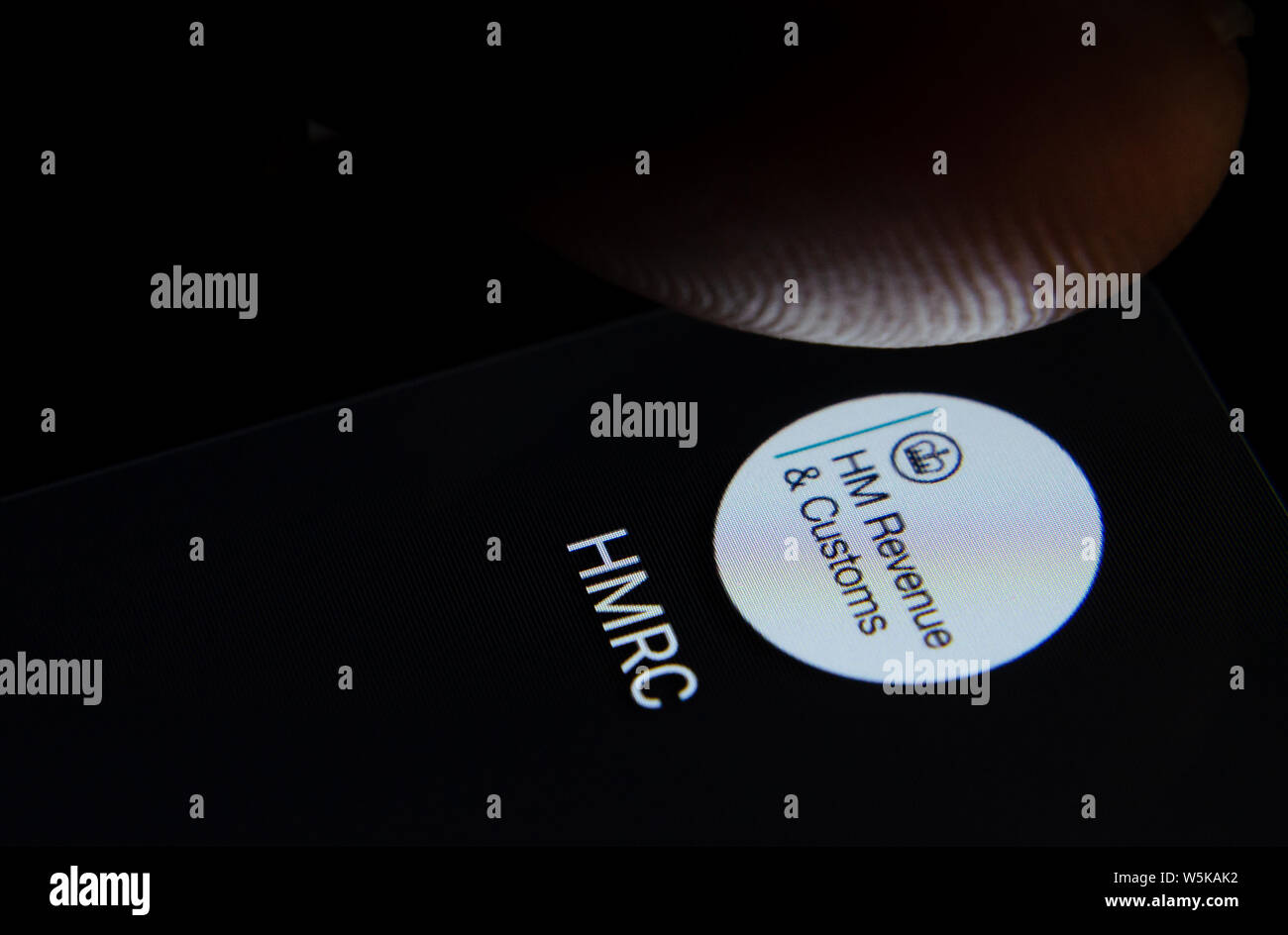 HMRC Icona app sullo schermo dello smartphone con pixel visibili e il dito per lanciare. Foto Stock