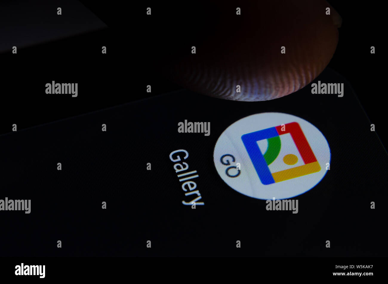 Google Galllery GO Icona app sullo schermo dello smartphone con pixel visibili e il dito per lanciare. Foto Stock