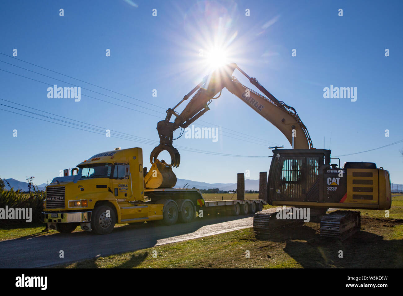 Sheffield, Canterbury, Nuova Zelanda, 10 Luglio 2019: Un escavatore viene trasportato da un carrello di grandi dimensioni a un sito di lavoro in una zona rurale Foto Stock