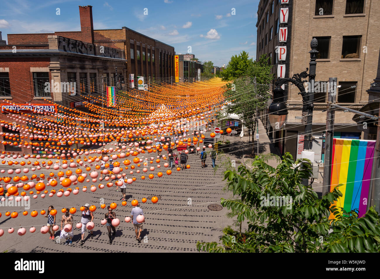 Montreal, CA - 1 Luglio 2019: la gente camminare al di sotto delle sfere di arcobaleno arte di installazione '18 tonalità di gay' su Saint-Catherine Street nel Villaggio Gay Foto Stock
