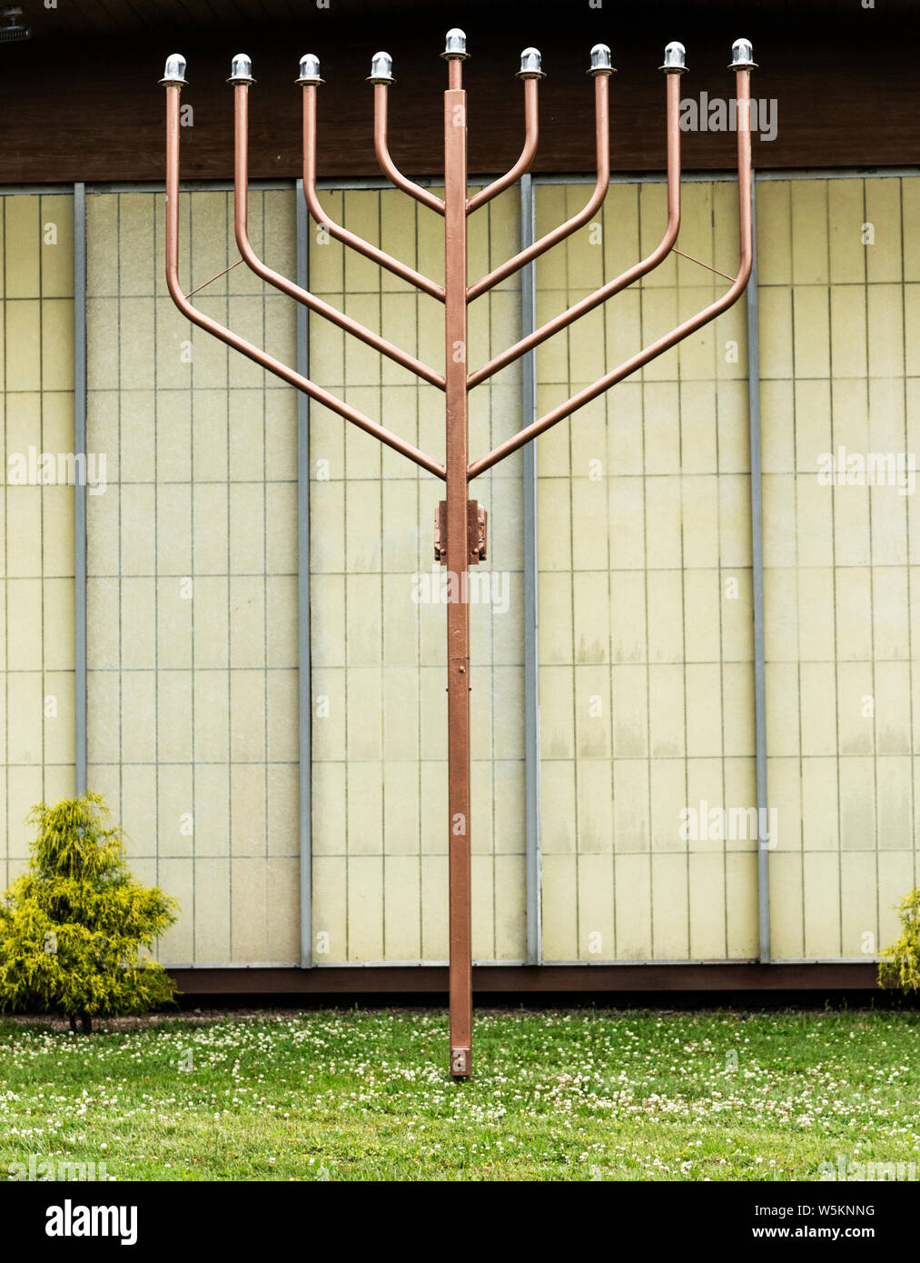 Una grande medaglia menorah sull'erba al di fuori di un tempio per celebrare le vacanze. Foto Stock