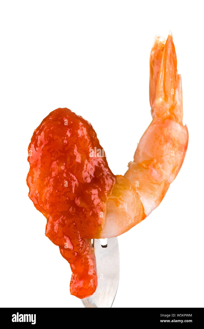 Un gamberi bolliti parzialmente coperto con salsa cocktail di sgocciolamento del fondo, sostenuto da una forcella. Foto Stock