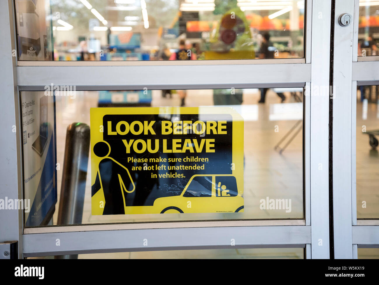 Segnale di avvertimento sulla porta d'ingresso alla città sul lago, Florida, Wal Mart store. Non lasciare bambini incustoditi in un'auto. Foto Stock
