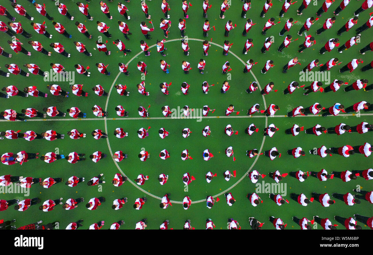 Migliaia di studenti della scuola primaria si riuniranno presso un campo di calcio per il canto e la lode madre paese in Shenyang City, a nord-est della Cina di Liaoning provin Foto Stock